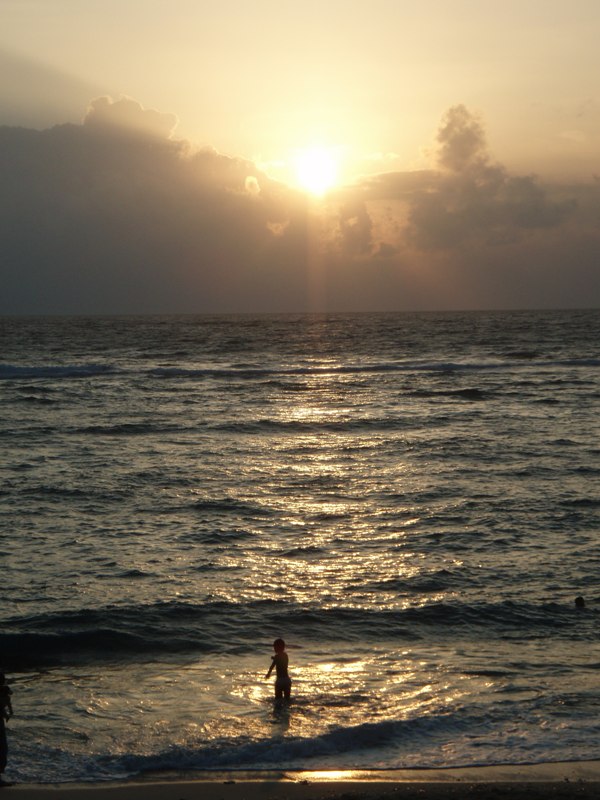 海で遊ぶ子供と夕日