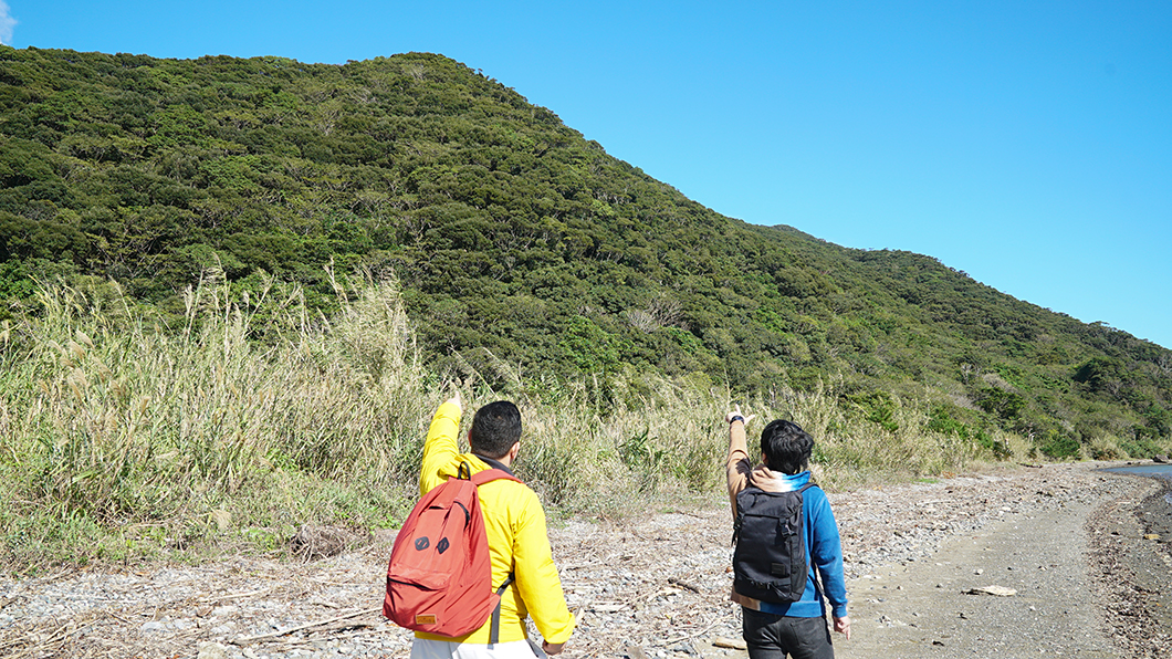 奄美市住用の山を指さす男の人