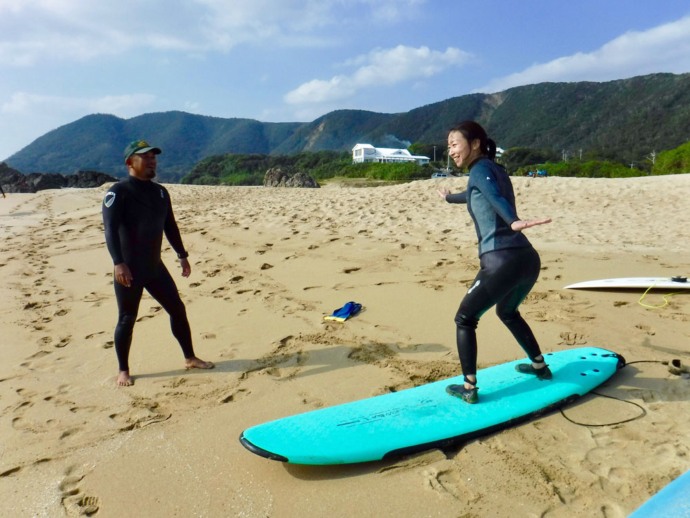奄美でサーフィンを体験する女性：GREENHILL