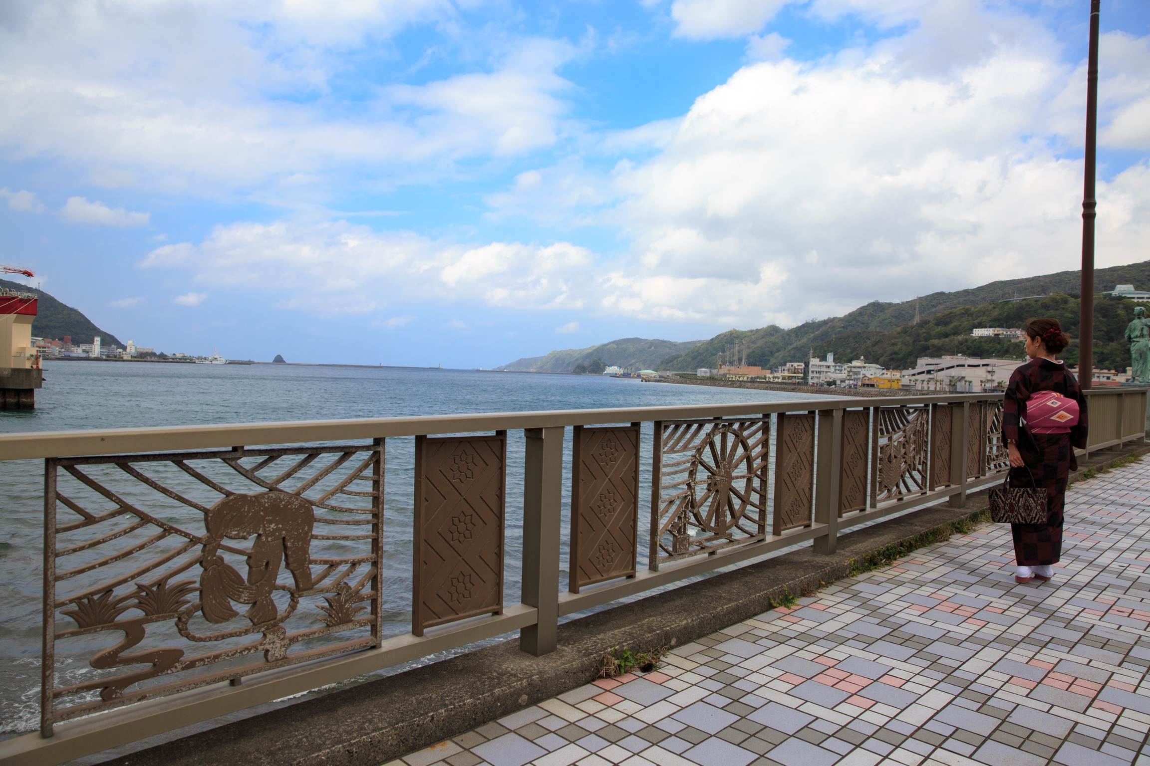 奄美名瀬港を見渡せる橋と大島紬姿の女性