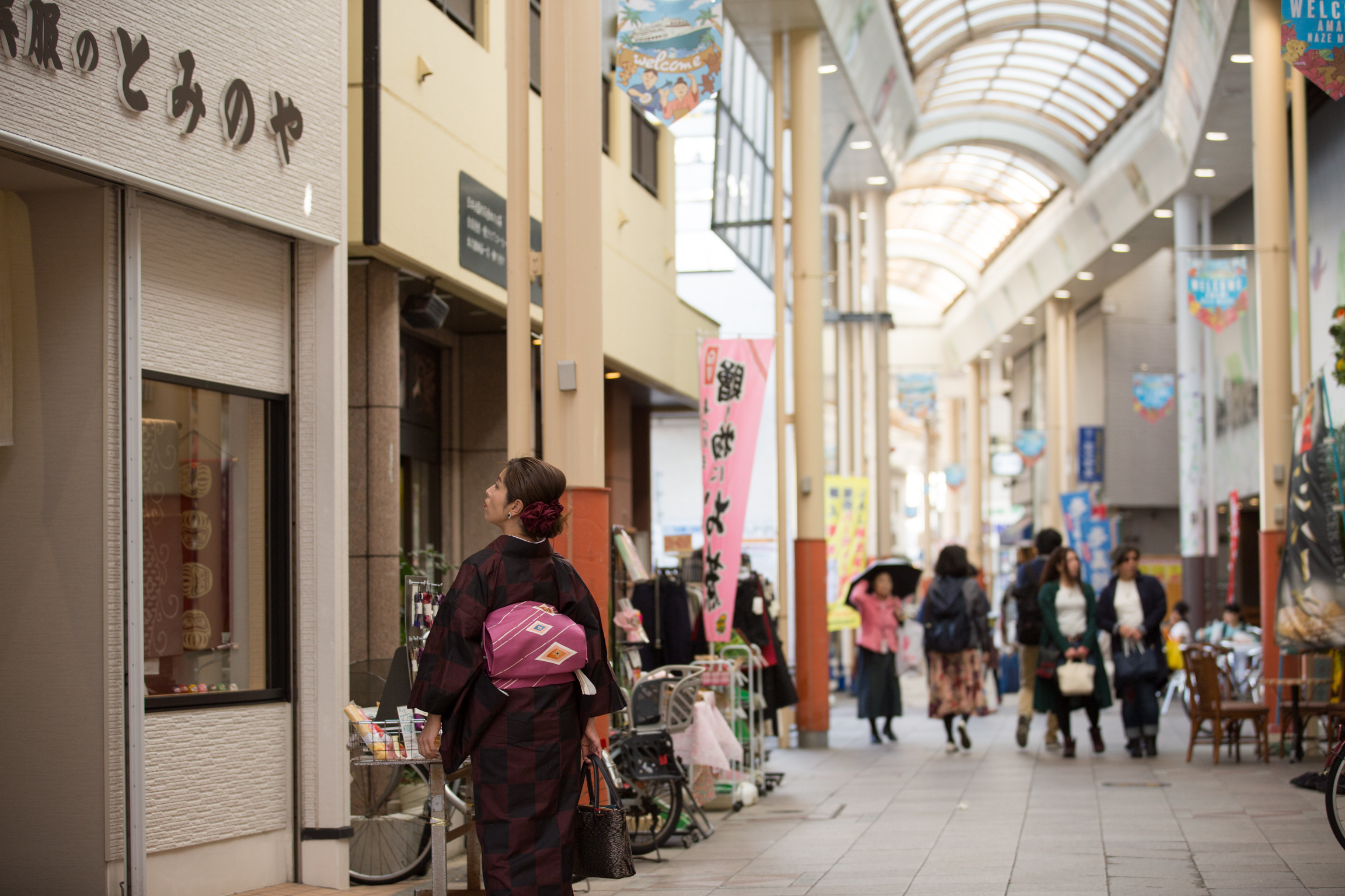 奄美大島名瀬市街地にあるアーケードを女性が歩く