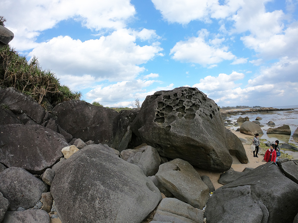 海岸の巨石を眺める女性