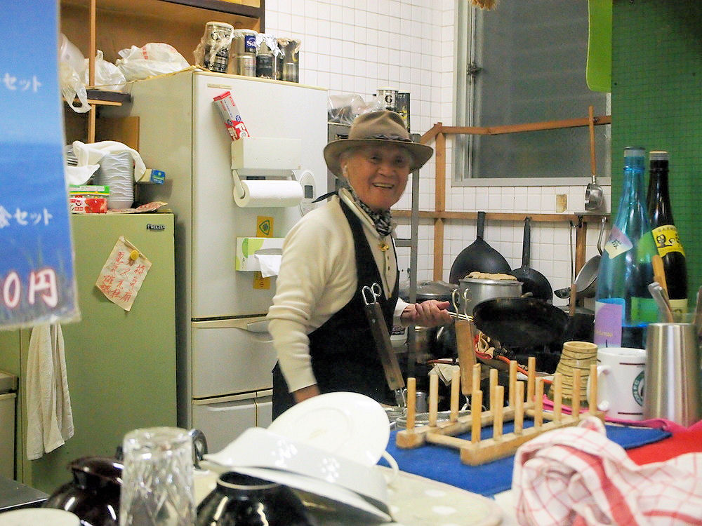 厨房で鍋を振る喫茶シャークの鮫島さん